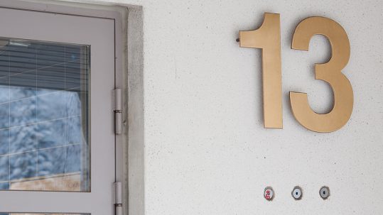 Messinki-irtokirjaimet kiinteistön numerointina. Kiinnitys piilotapein ja korokeholkein.