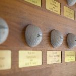 Hole in one -taulu. kaiverretut messinkikilvet upotettu mahonkilevyyn