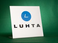 Alumiinikyltti. Yrityksen logokyltti on valmistettu särmättyyn alumiiniin. Logo on leikattu tarrakalvosta.