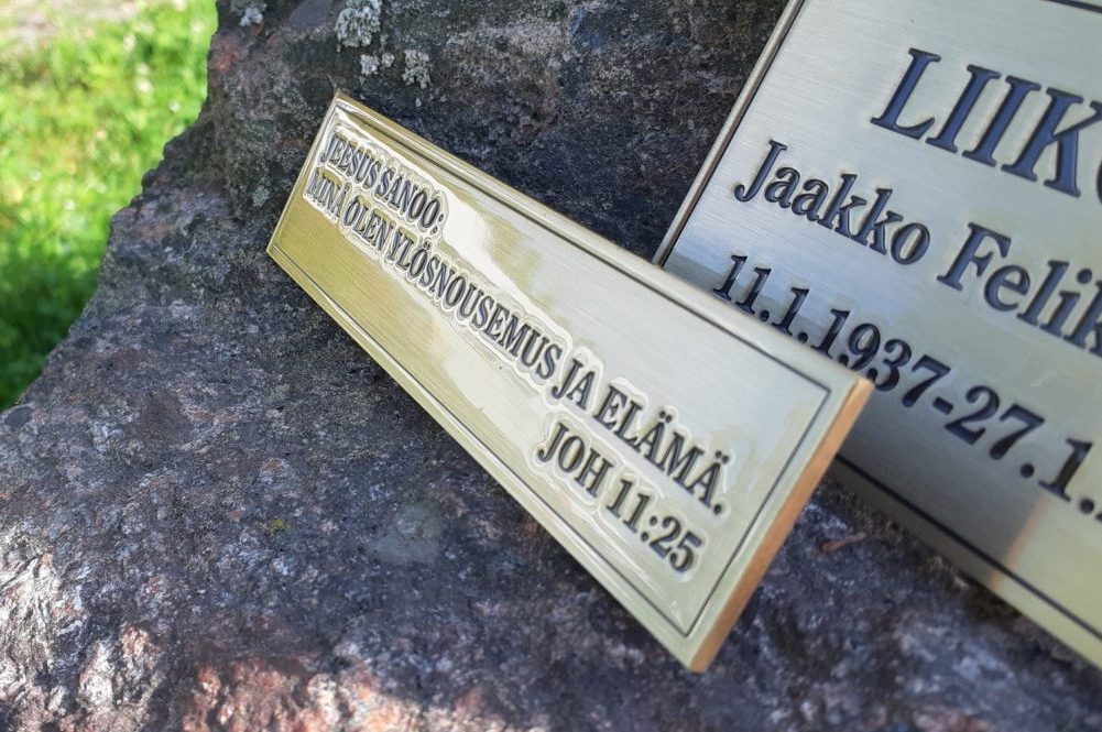 Muistolaattaan on kaiverrettu ja patinoitu tekstit, viimeistelynä lakkaus.