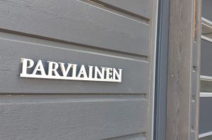 Nimikyltti ulko-oven viereen alumiini-irtokirjaimista. Kiinnitys piiloruuvit koroketapein.