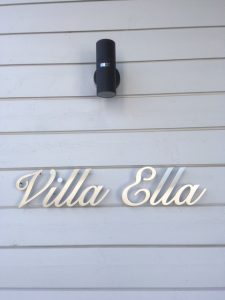 Talon nimikyltti ruostumatonta terästä, kiinnitys seinään piilotapeilla korokeholkein.