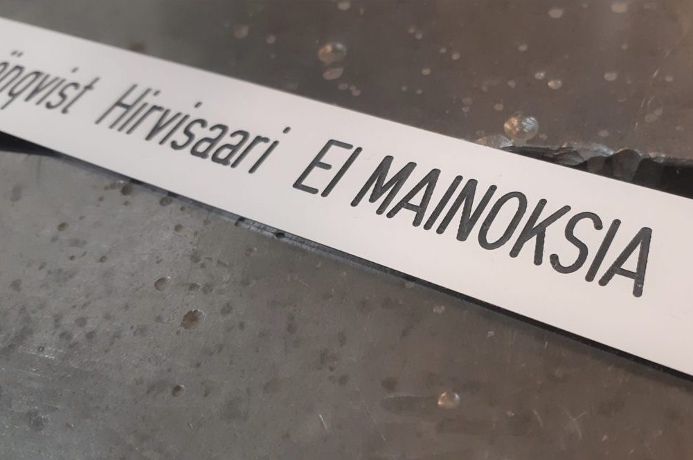 Ei mainoksia -merkki on kaiverrettu postilaatikon nimikyltin yhteyteen.