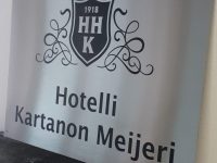 Hotellin nimikilpi on valmistettu ruostumattomasta teräksestä. Nimi ja logo tarratekstillä.