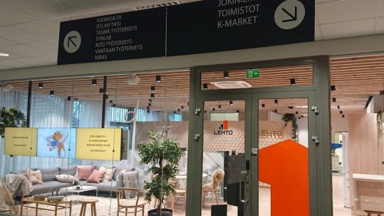 Katto-opaste alumiinikomposiittilevyä, valkoiset tarratekstit.