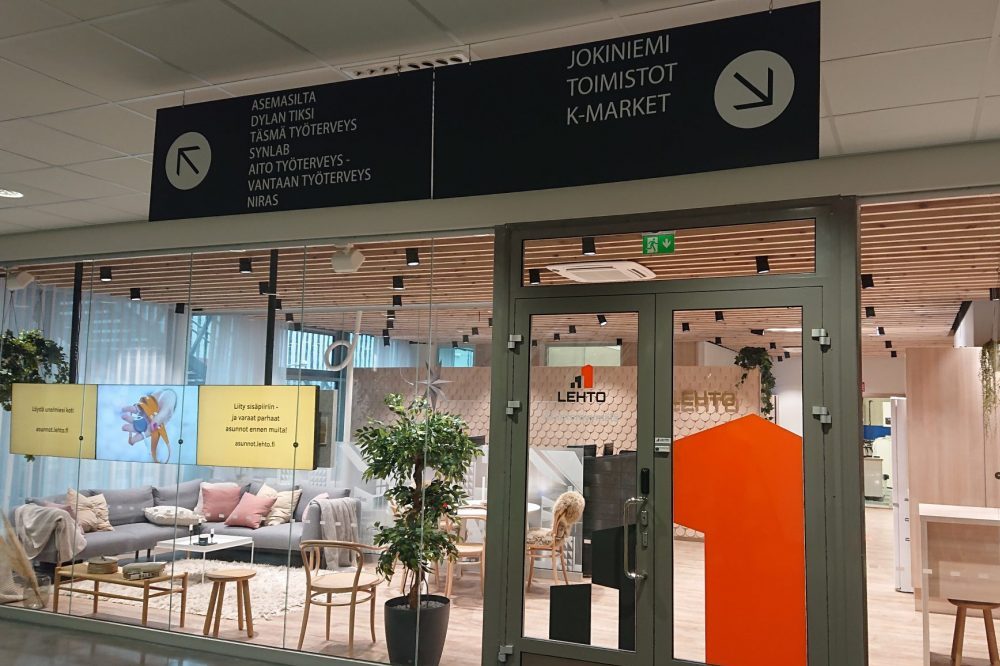Katto-opaste alumiinikomposiittilevyä, valkoiset tarratekstit.